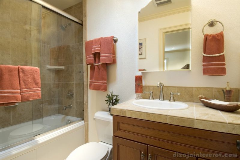 modern bathroom, showe with glass doors and tile,sink and toilet, matching towels