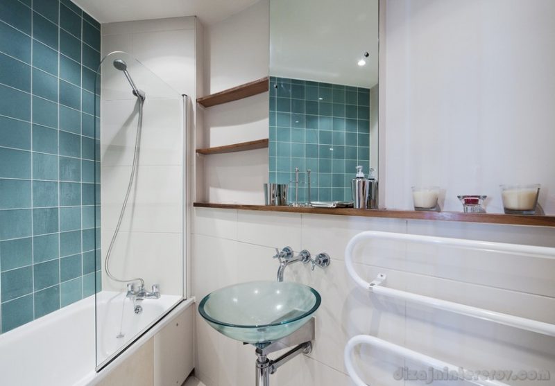 Modern bathroom with green tiles and glass hand wash basin