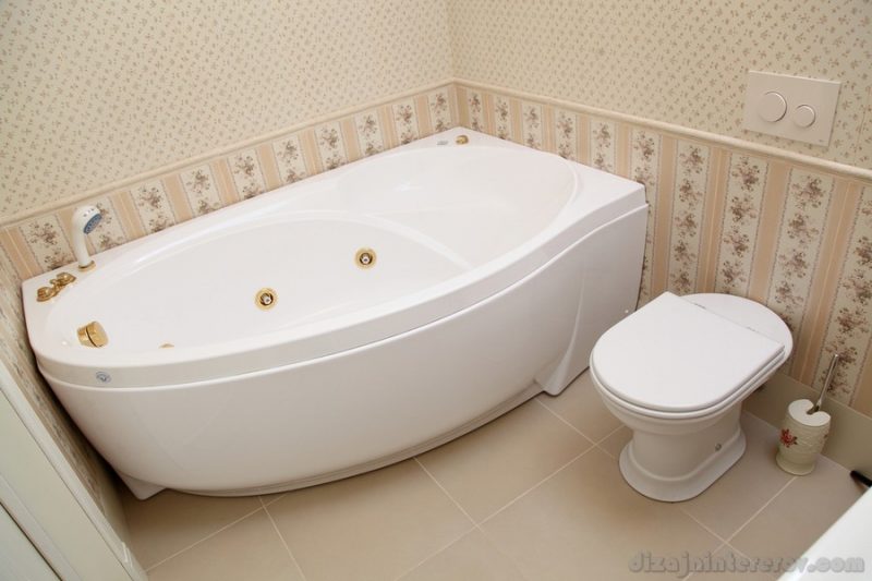 Bathroom in beige color with a big white bathroom and a toilet