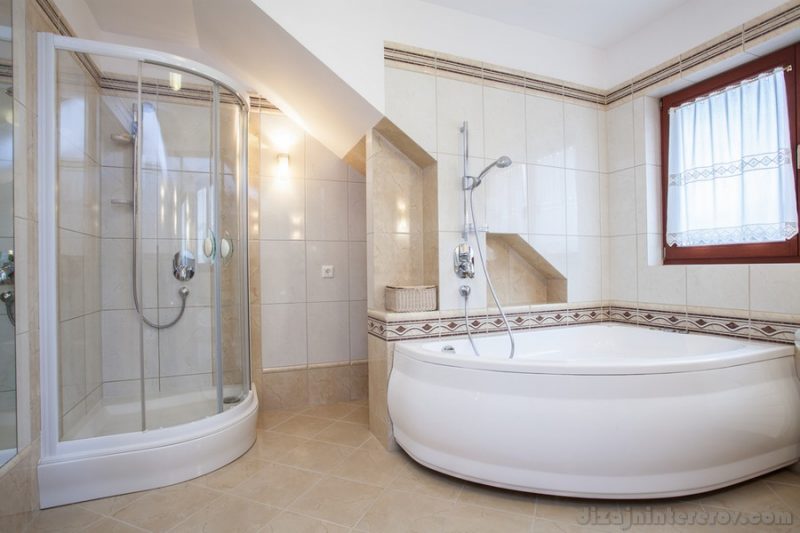 Shower and big bath in beige bathroom interior