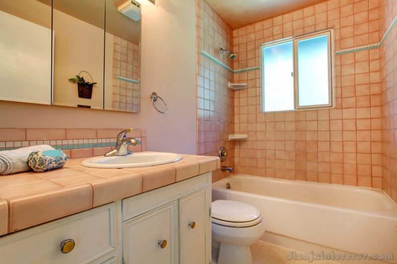 Warm bathroom interior in soft peach color with tile wall trim