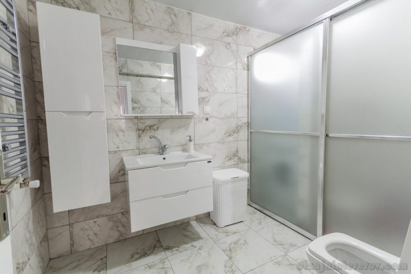 Clean, modern bathroom interior with white sink, faucet and closet