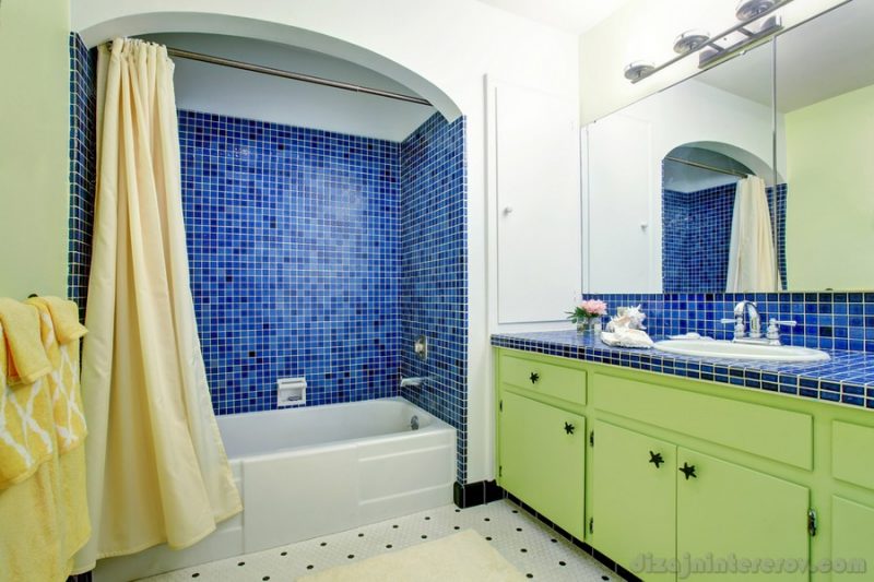 Modern bathroom interior with green cabinets and blue counter top. Northwest, USA