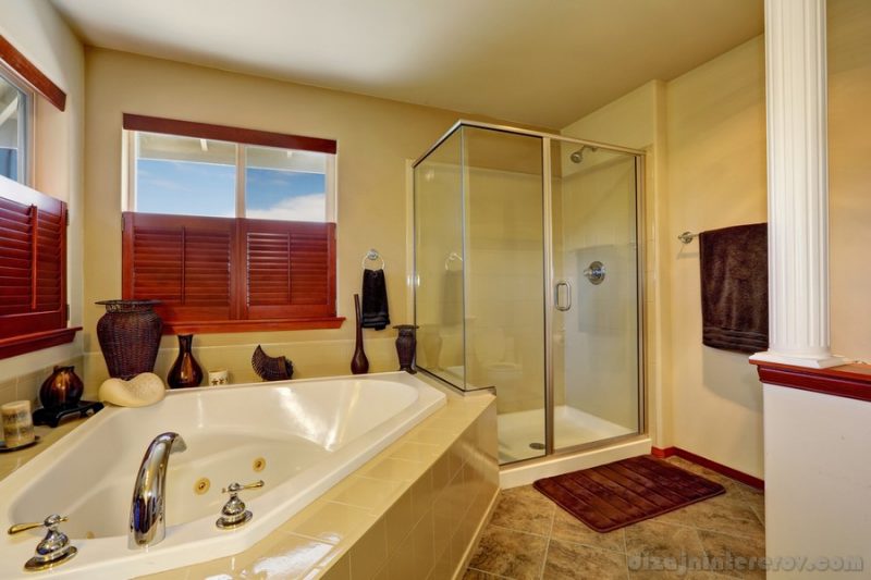 Luxury bathroom with corner bath tub and glass shower. Marble tile floor and beige walls. Northwest, USA