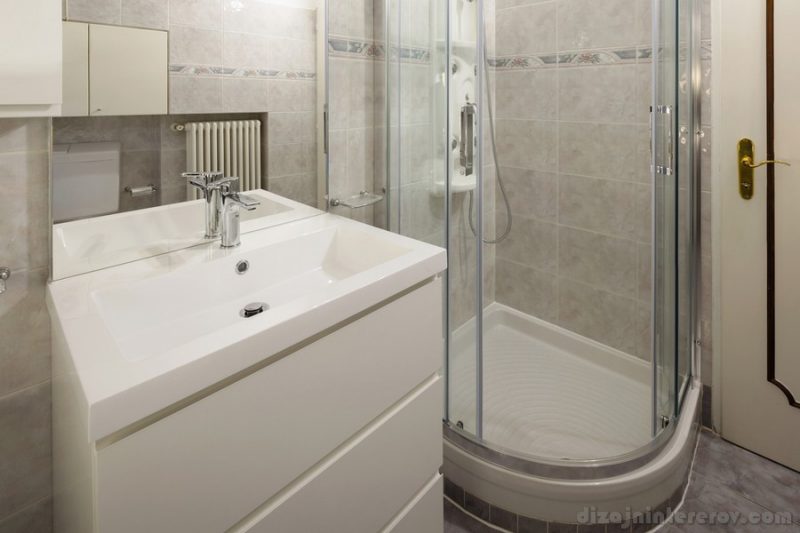 Bathroom with tiles and a large shower. Nobody inside