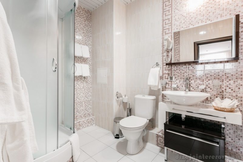 Bathroom Inside rooms of a apartment or hotel. Clean white towel and bathrobe on a hanger prepared to use